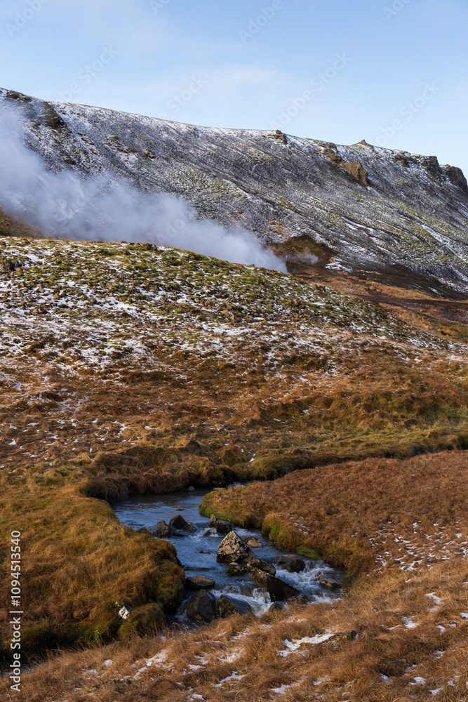 Obraz premium Scenic view of the Reykjadalur hot springs area, with a hot stream flowing through a picturesque valley