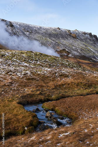 Scenic view of the Reykjadalur hot springs area, with a hot stream flowing through a picturesque valley