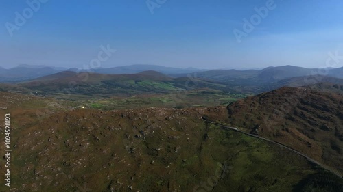 Caha Pass, County Cork, Ireland, September 2024. Drone ascends above a winding road via Turners Rock Tunnel into County Kerry through the grassy rugged mountain slopes. photo