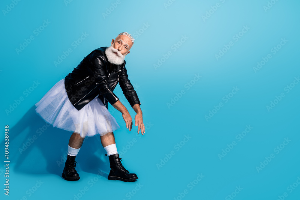 Photo of extravagant senior man non binary stepping moving dance wear female clothes isolated blue color background Photo of extravagant senior man non binary stepping moving dance wear female clothes isolated blue color background