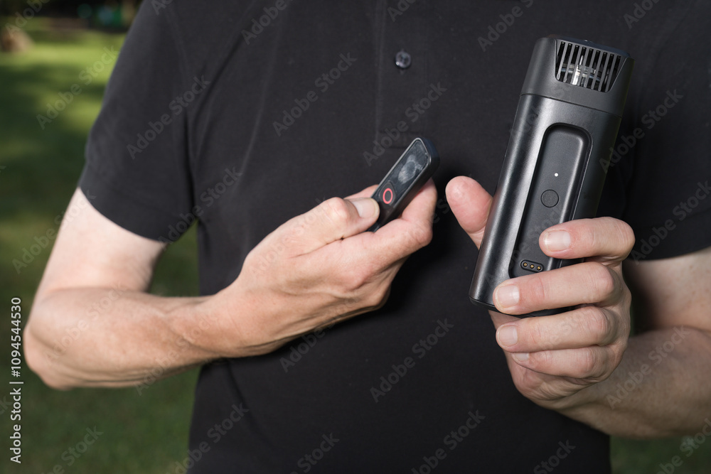 Fototapeta premium Older man uses two types of smoke machine generators on outdoor location