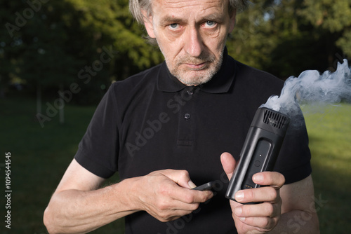 Older man uses two types of smoke machine generators on outdoor location