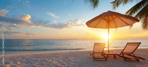 Relaxing beach sunset with lounge chairs and an umbrella by the shore