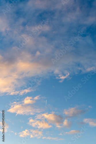 Bright blue sky with golden fluffy clouds