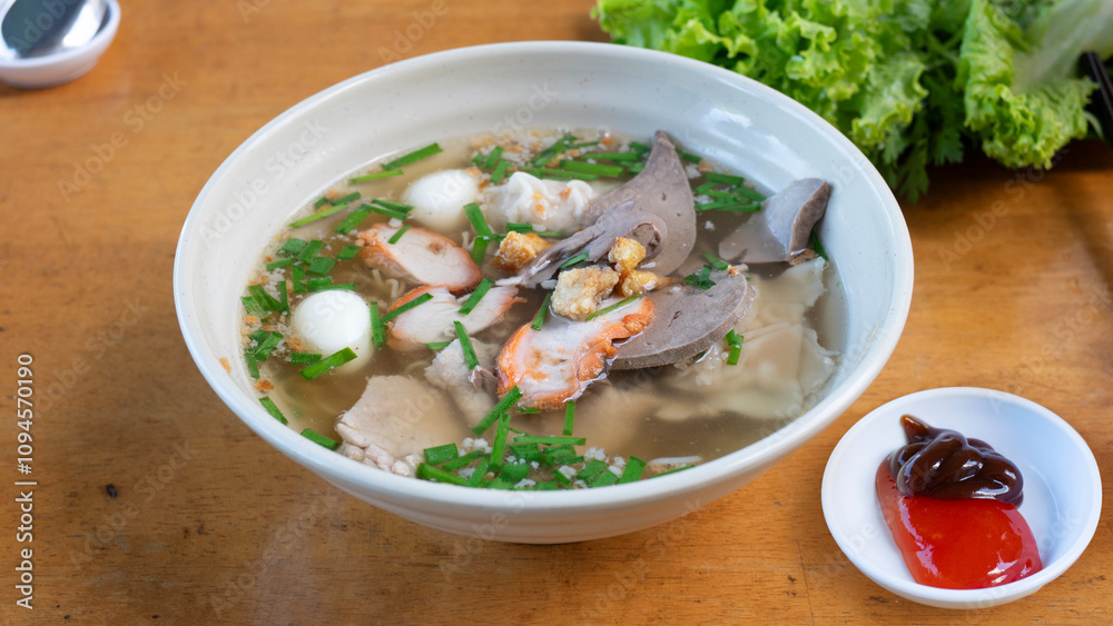 Egg noodles with pork wonton soup or pork dumplings soup and vegetable isolated. Chinese egg noodle topping slice roasted pork and wontons Egg noodles with pork wonton soup or pork dumplings soup and vegetable isolated. Chinese egg noodle topping slice roasted pork and wontons