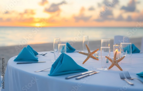 Elegant beachside dining setup with blue accents during sunset near the ocean