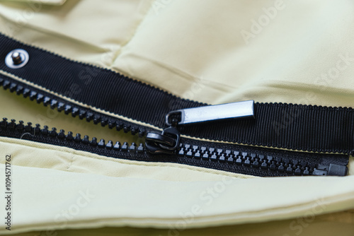 Close-up of the black plastic zipper on the outerwear. Accessories for making clothes, textiles. Concept of haberdashery. photo