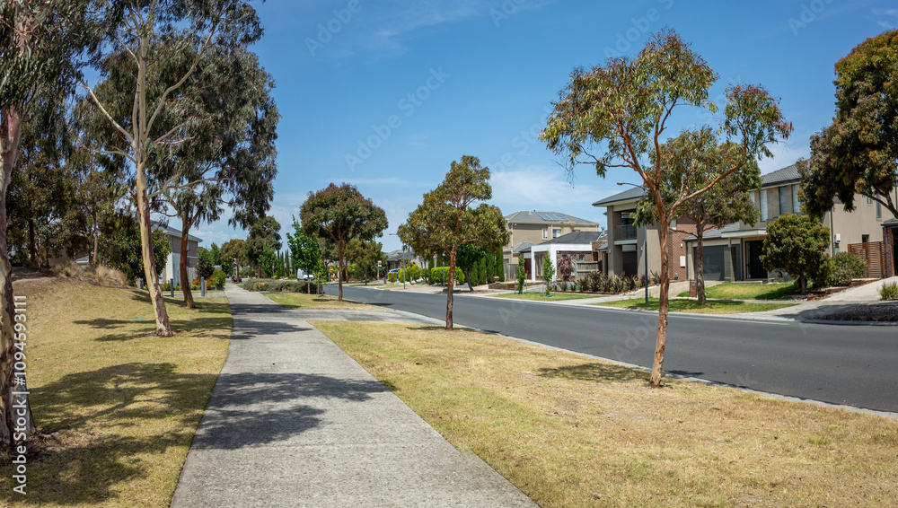 Panoramic view of a modern suburban street with eucalyptus trees and contemporary homes along the residential road. Point Cook Melbourne Australia Panoramic view of a modern suburban street with eucalyptus trees and contemporary homes along the residential road. Point Cook Melbourne Australia