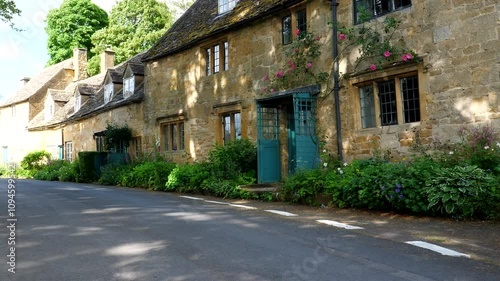 Yellow brick house terrace in Snowshill, small village in Cotswolds, panning shot on a sunny summer day.