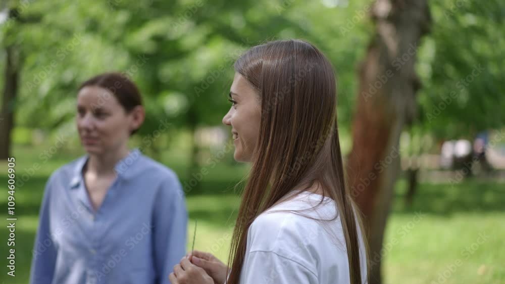 A group of women sharing laughter and engaging in a cheerful conversation in a serene park setting. The vibrant greenery and natural light create a warm and relaxed atmosphere, highlighting the joy of A group of women sharing laughter and engaging in a cheerful conversation in a serene park setting. The vibrant greenery and natural light create a warm and relaxed atmosphere, highlighting the joy of
