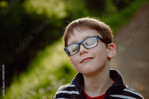 young boy wearing glasses in stripey casual jumper 