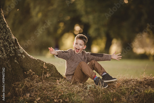 young happy boy sitting on a tree
