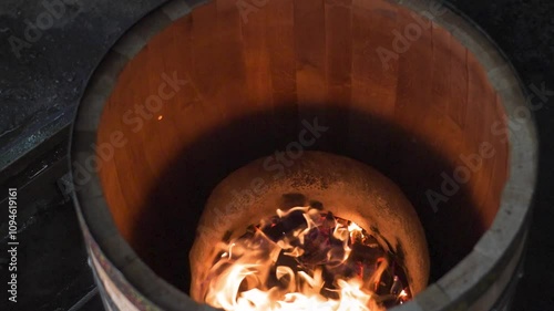charring the inside of a wooden barrel with fire