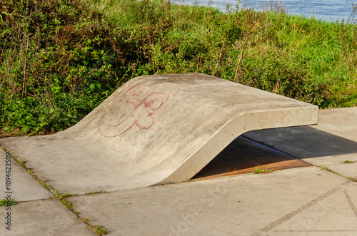 Zutphen, The Netherlands, September 28, 2024: creatively shaped concrete bench by the riverside photo