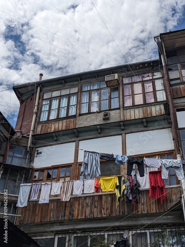 old courtyard in Tbilisi, Georgia, in which clothes are dried on lines, wood house, building