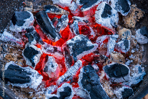 Glowing Hot Charcoal Embers with Vibrant Red Heat and White Ash in Extreme Close-up. Burning Wood Coals Create Abstract Patterns of Fire and Cinders in Dramatic Macro Photography photo