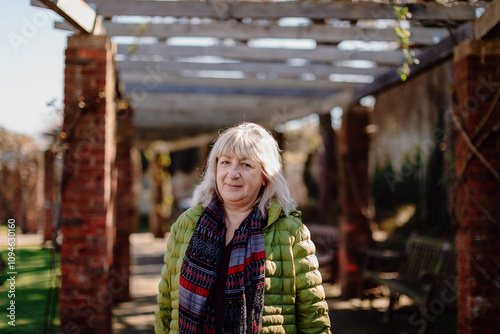 Mature woman walking outdoors in urban setting wearing winter jacket
