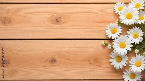 A bouquet of white daisies with yellow centers is arranged diagonally on a wooden surface, creating a visually appealing composition.