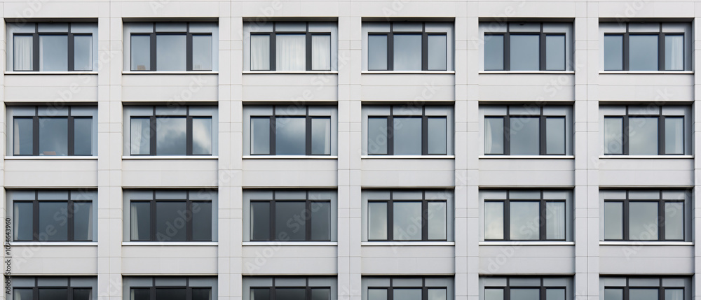 A modern building featuring sleek architecture with closed windows, showcasing a minimalist and urban design. A modern building featuring sleek architecture with closed windows, showcasing a minimalist and urban design.