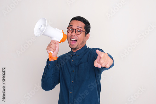 A man looking and pointing at the camera with excited expression while holding megaphone photo