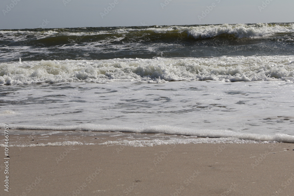 Close-up of ocean waves rolling onto a sandy beach, showcasing the dynamic beauty of nature and coastal life Close-up of ocean waves rolling onto a sandy beach, showcasing the dynamic beauty of nature and coastal life