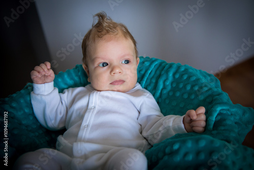 newborn baby in sleepsuits on a blanket photo