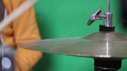 Playing A Drumstick On A Hi-Hat On Green Background Close-Up