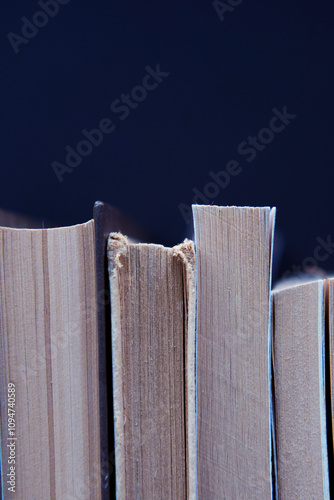 Row of old books, black background.