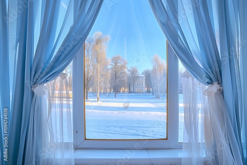 Bright winter morning view through a window with light blue curtains framing the sides and white tulle curtains open to reveal a sunny park and clear blue sky.