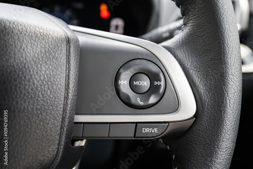Close-up view of a modern car steering wheel with various driver control buttons