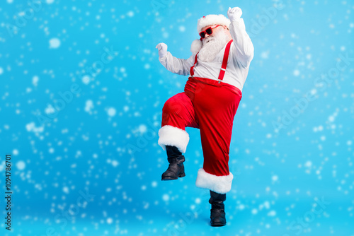 Full length photo of cool hipster fat santa claus dance x-mas christmas tradition discotheque wear suspenders overall sunglass boots isolated over blue color background photo