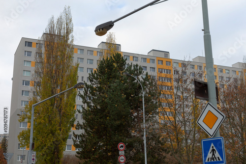 An image of an apartment building with street signs and traffic lights, reflecting modern city life