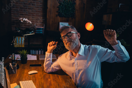 Photo of handsome mature man tired sleepy stretching wear white shirt formalwear office evening light room interior indoors workspace photo