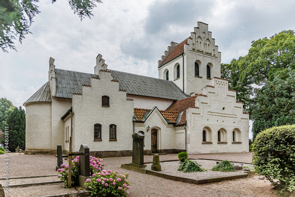 a whitewashed stone church with stepped gables in Skåne Sweden