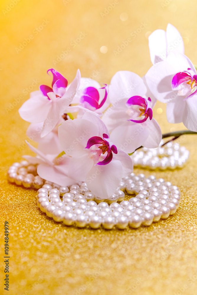 A branch of white orchids on a shiny gold background

