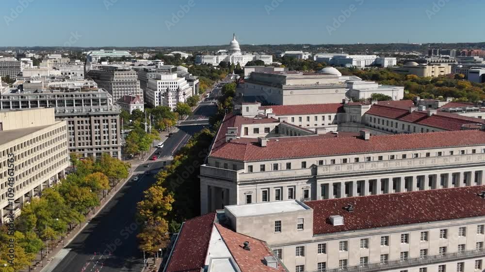 Aerial view of Washington DC featuring a cityscape with various buildings, including the iconic Capitol Building, a street lined with trees, and a large government building with a tiled roof. Aerial view of Washington DC featuring a cityscape with various buildings, including the iconic Capitol Building, a street lined with trees, and a large government building with a tiled roof.