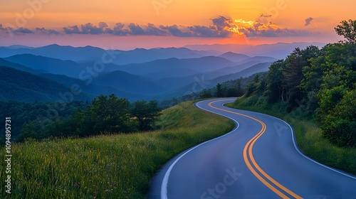 Scenic mountain road curves through rolling hills at sunset, golden sky and dramatic clouds create cinematic landscape with perfect perspective. photo