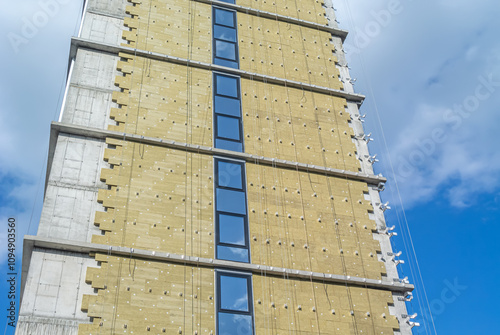 Construction work on the exterior cladding. Laying of thermal insulation material on the walls. Insulation of the house. Preparing the house for winter. The wall of a house under construction.