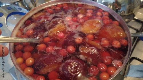 Mixed sour cherry, apricot and plum compote made by boiling in a pot,