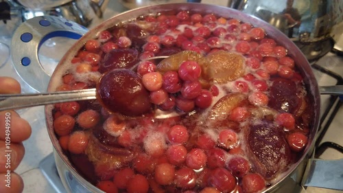 Mixed sour cherry, apricot and plum compote made by boiling in a pot,