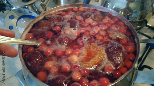 Mixed sour cherry, apricot and plum compote made by boiling in a pot,