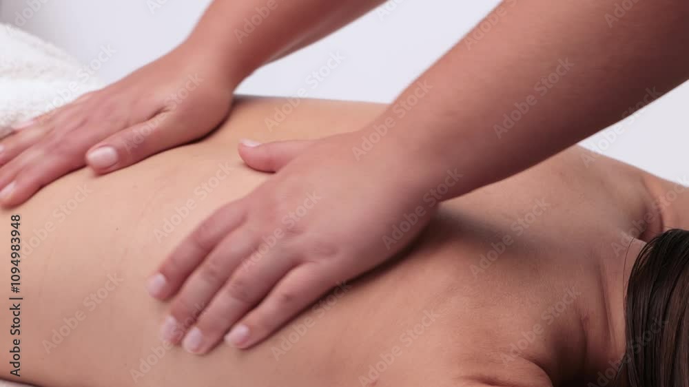 Masseur makes a relaxing massage on the neck, shoulders, back and collarbones of a young beautiful woman in a spa. Treatment for back pain. Masseur makes a relaxing massage on the neck, shoulders, back and collarbones of a young beautiful woman in a spa. Treatment for back pain.