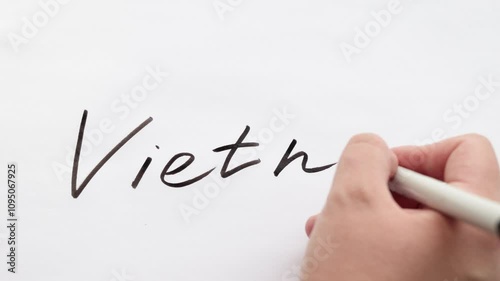 Hand writing the word Vietnam on white paper background. World politics, news or tourism concept, close up  photo