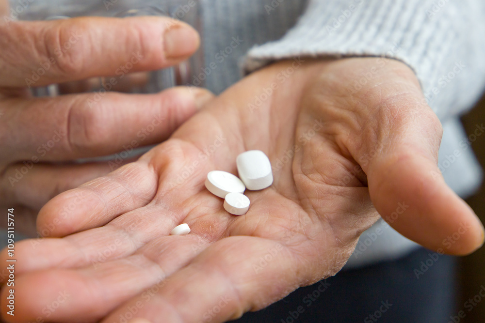 An old woman holds pills in her hands. Close up view. An old woman holds pills in her hands. Close up view.