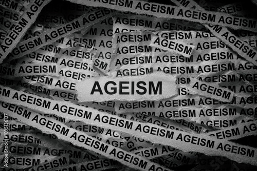 Strips of newspaper with the words Ageism typed on them. Black and white. Close up.