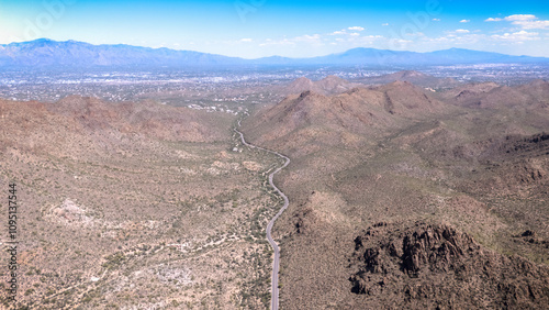 Arizona desert landscape. A road winds its way through the red rocks and green sahuaros towards Tucson. photo