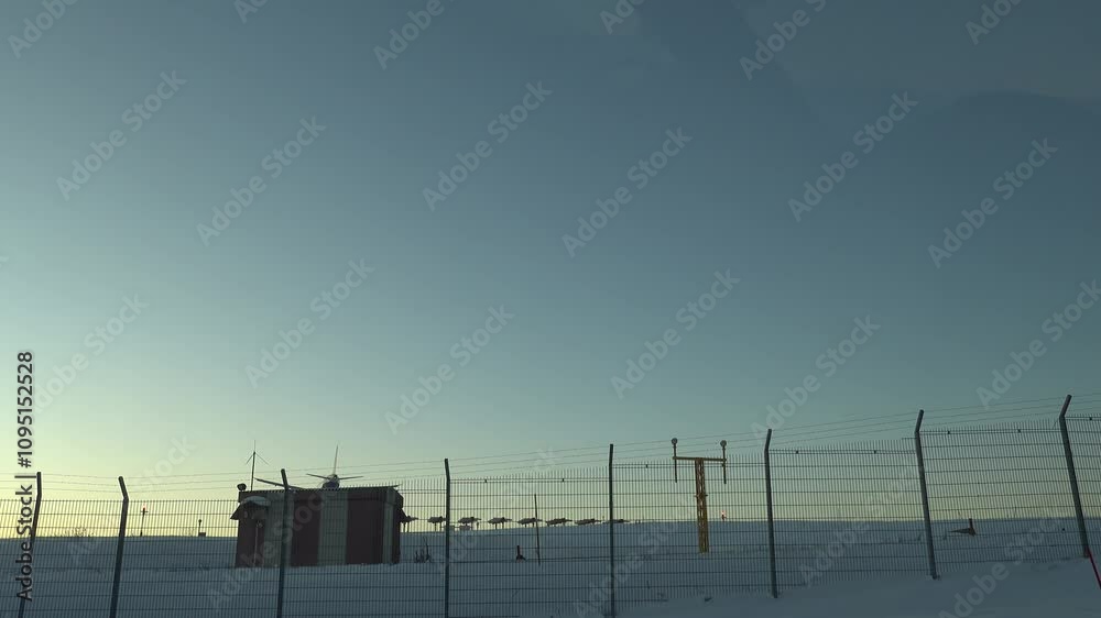Stockholm, Sweden A plane lands at Arlanda Airport over a snowy landscape at sunset. 