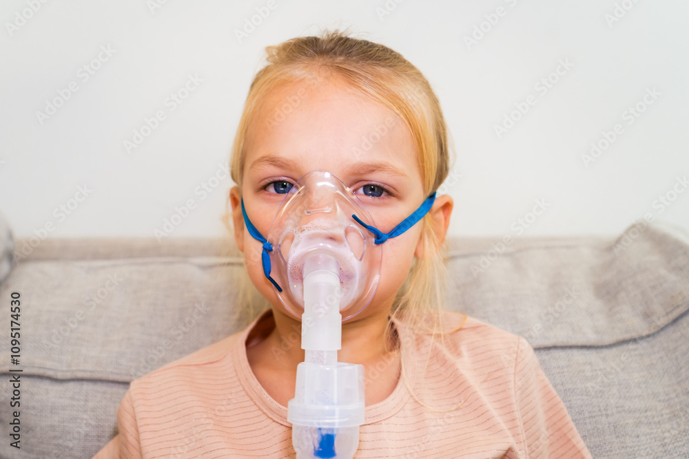 Young girl uses a nebulizer at home for respiratory treatment during the afternoon Young girl uses a nebulizer at home for respiratory treatment during the afternoon