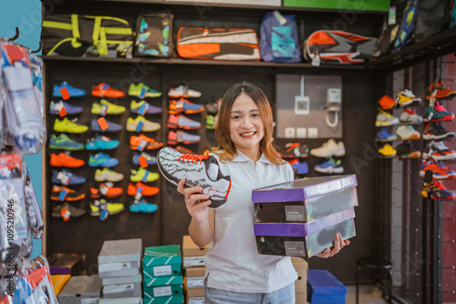Wallpaper Mural smiling saleswoman holding athletic shoe and box when working at sport footwear store Torontodigital.ca