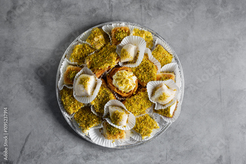 A top down view of a catering tray of a mix of kunafa, halawet el jibn, shaabiyat, aish el saraya. photo